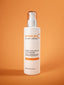 pomegranate cleanser bottle on orange background by neeltje