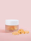 hydra repair capsules in jar with some loose capsules on pink background by neeltje 