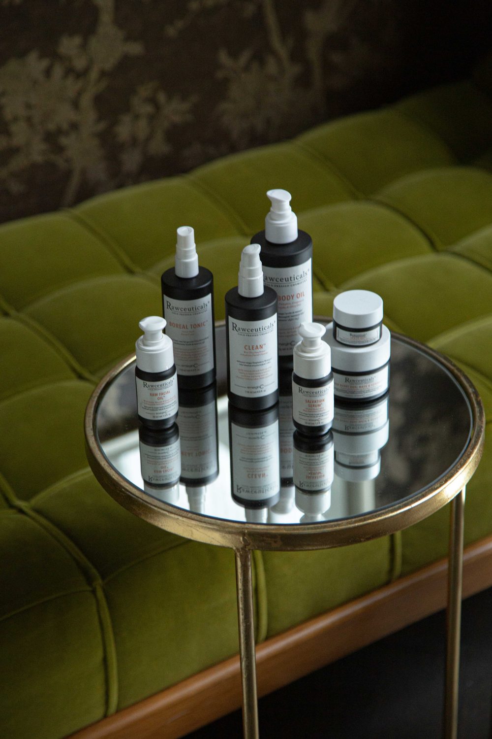 All emerginC Rawceuticals products on table next to green velvet sofa